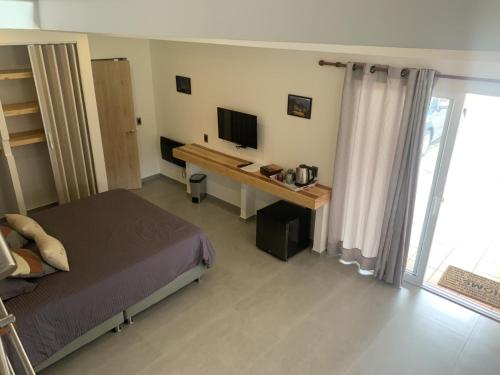 1 dormitorio con 1 cama y escritorio con TV en chez Yannick, en Salento
