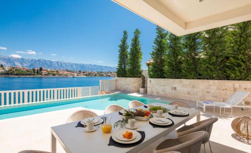 a patio with a table and chairs and a swimming pool at Villa More in Selca