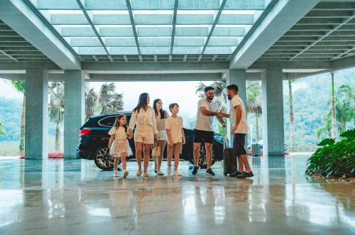 a family standing in front of a car at Fazzenda Park Resort in Gaspar