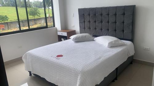 1 dormitorio con 1 cama grande y cabecero grande en HOTEL EL CACIQUE POPAYAN, en Popayán
