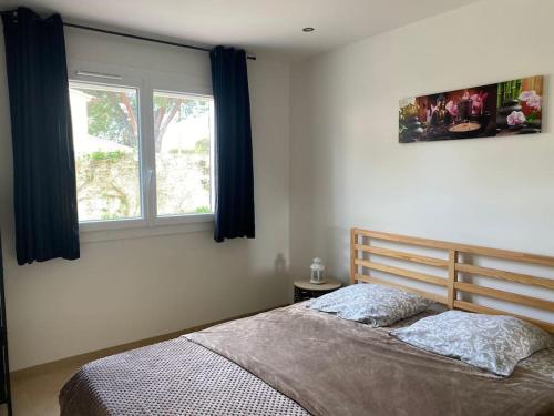 une chambre avec un lit et deux fenêtres dans l'établissement Les clés du Sud Bormes 35m2, à Bormes-les-Mimosas