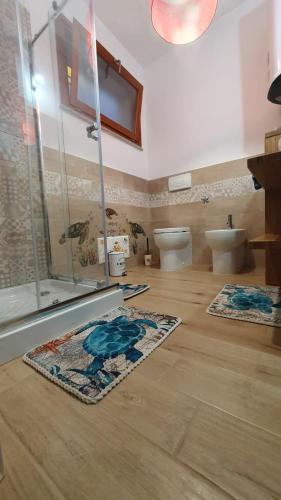 a bathroom with two rugs on a wooden floor at VillaVittoria in Chia