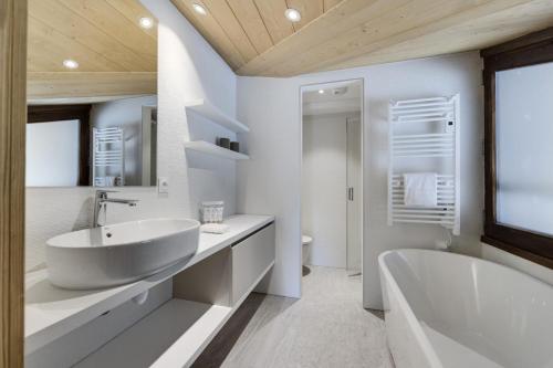 a white bathroom with a tub and a sink at Résidence Les Alpages - 5 Pièces pour 8 Personnes 714 in La Rosière