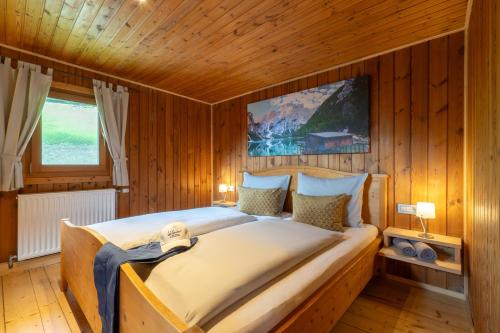 una camera da letto con un grande letto in una camera in legno di Chalet Kasern a Gais
