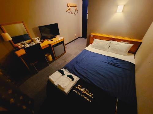 a small hotel room with a bed and a desk at HOTEL SEAGULL - Vacation STAY 36269v in Izumi-Sano