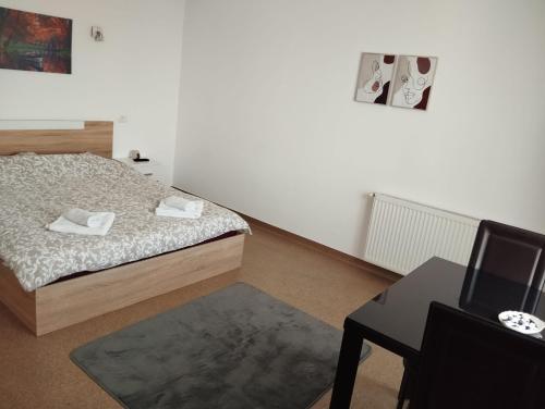 a bedroom with a bed and a desk with a computer at Hotel ENZO in Voluntari