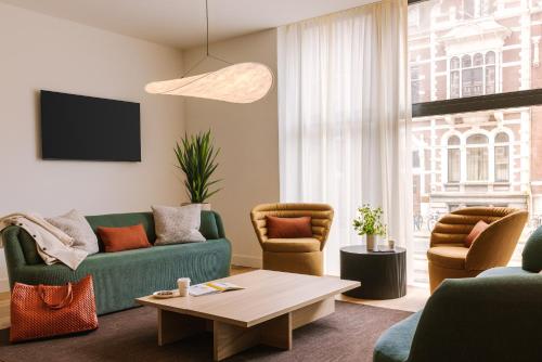 a living room with a couch and chairs and a table at Sonder Rose in Rotterdam