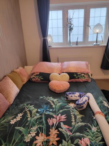 a bed with two stuffed animals and pillows on it at Chocolates&Flowers in Leverstock Green