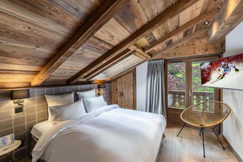 ein Schlafzimmer mit einem weißen Bett in einem Zimmer mit Holzdecken in der Unterkunft Résidence Casa Martinha D'arbois - Chalets pour 8 Personnes 004 in Megève
