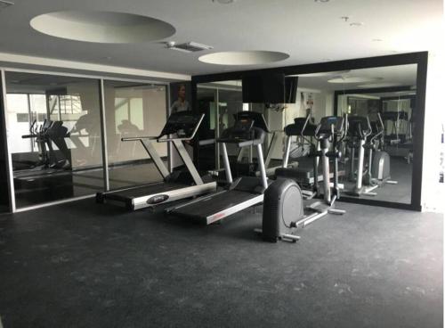 een fitnessruimte met verschillende loopvlakken en spiegels bij Lujosa Suite; confort, seguridad in Guayaquil