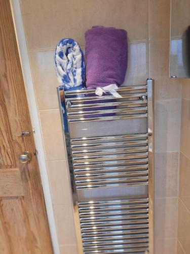 Leverstock Green的住宿－Chocolates&Flowers，毛巾架,带紫色毛巾的淋浴间