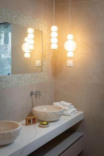 a bathroom with two sinks and a mirror and lights at Villa More in Selca