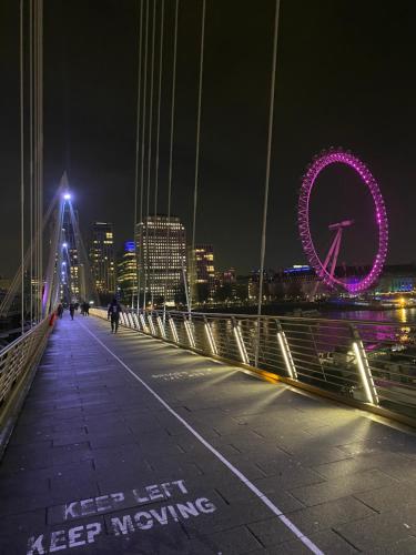 Un puente con el ojo de Londres iluminado por la noche en Flat The Shard, en Londres