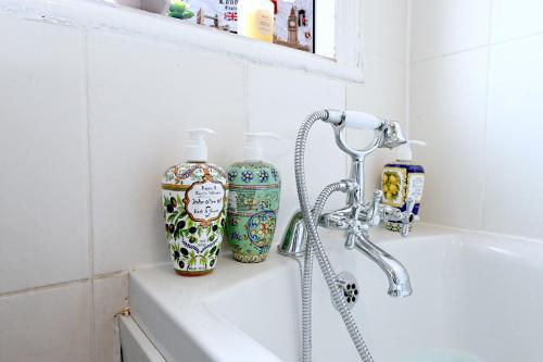 ein Badezimmer mit zwei Flaschen auf einem Waschbecken in der Unterkunft STUNNING 3 Bedroom Serviced Flat IN North London in London