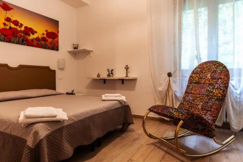 1 dormitorio con cama, silla y lavamanos en AI Giardini en Castelnuovo di Val di Cecina
