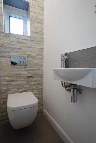 La salle de bains est pourvue de toilettes blanches et d'un lavabo. dans l'établissement Milton Place, à Londres