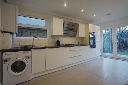 a kitchen with a washer and dryer in it at Milton Place in London