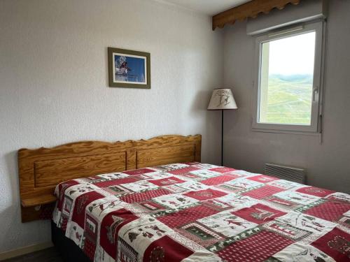 a bedroom with a bed with a red and white quilt at Résidence Hauts De Peyragudes Mp - 2 Pièces pour 6 Personnes 894 in Germ