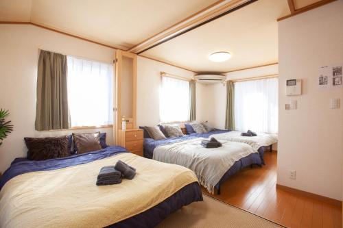 two beds in a room with windows at Lucky Higashi Mizue - Vacation STAY 16180 in Tokyo