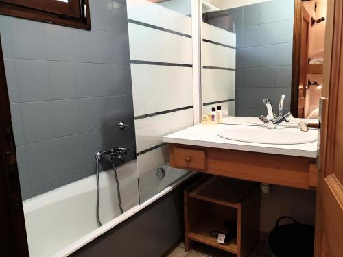 ein Badezimmer mit einem Waschbecken und einer Badewanne in der Unterkunft Residence La Corniche - Studio pour 4 Personnes 154 in Morzine