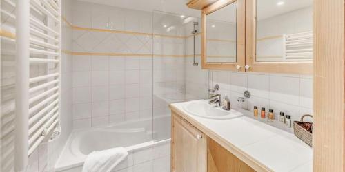 une salle de bain blanche avec une baignoire et un lavabo dans l'établissement Résidence Les Alpages - 4 Pièces pour 8 Personnes MAE-3904, à Champagny-en-Vanoise