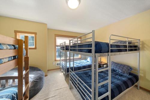 Un dormitorio con tres literas en una habitación. en Sandpiper House-Manzanita Or, en Manzanita