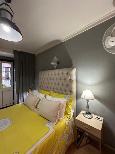 リスボンにあるapartamet in Bairro alto 1のベッドルーム(黄色のベッド1台、ランプ付)