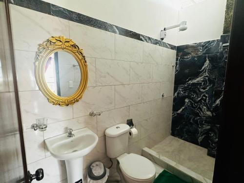 a bathroom with a sink and a toilet and a mirror at Casa Palmamar in Olón