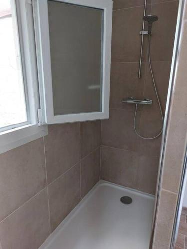 La salle de bains est pourvue d'une douche, d'une fenêtre et d'une baignoire. dans l'établissement Brand new studio with garden, easy access to Paris, à Sartrouville