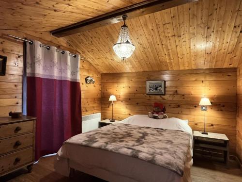 a bedroom with a bed and a wooden wall at Chalets Abbe/tot - Chalet de l'abbé MAE-3994 in Crest-Voland