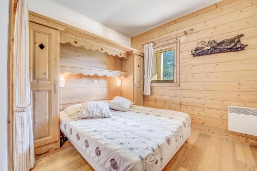 une chambre avec un lit dans une pièce en bois dans l'établissement Résidence Les Alpages - 3 Pièces pour 6 Personnes MAE-7284, à Champagny-en-Vanoise