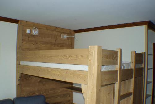 Ce lit superposé se trouve dans un dortoir doté de murs en bois. dans l'établissement Résidence La Marelle et Le Rami - maeva Home - Studio 4 personnes - Sélection MAE-7724, à La Plagne Tarentaise