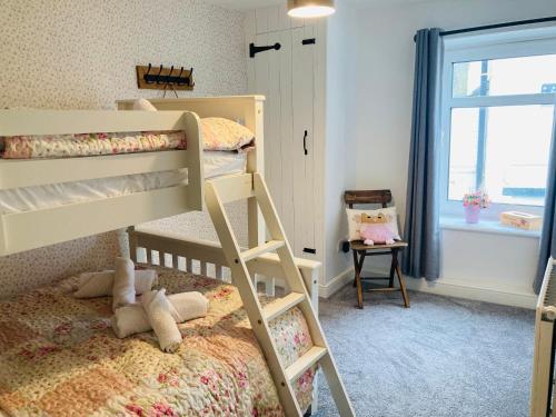sypialnia z 2 łóżkami piętrowymi i oknem w obiekcie Adlington Cottage, Lancashire w mieście Adlington