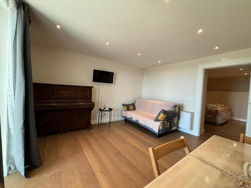 a living room with a piano and a couch at Villa Patrizia Pietrasanta in Pietrasanta