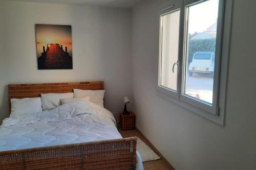 - une chambre avec un lit et une fenêtre avec une photo dans l'établissement Les clés de Bormes 40 m2, à Bormes-les-Mimosas