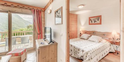 une chambre avec un lit et un balcon dans l'établissement Résidence Les Alpages - 3 Pièces pour 6 Personnes MAE-7294, à Champagny-en-Vanoise