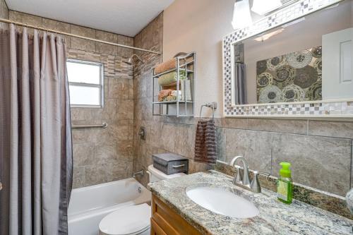 a bathroom with a sink and a toilet and a mirror at Auburndale Vacation Rental with Yard and Lake Views in Auburndale