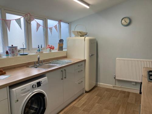 a kitchen with a refrigerator and a washing machine at Adlington Cottage, Lancashire in Adlington