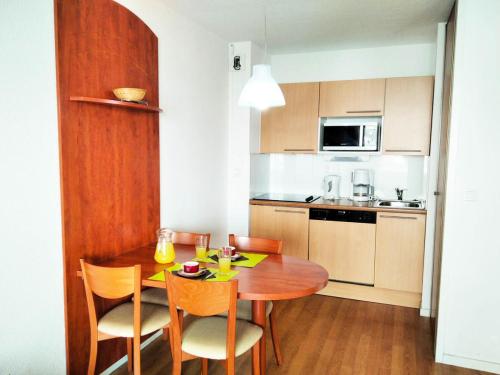 une petite cuisine avec une table et des chaises en bois dans l'établissement Résidence Pic Du Midi - Apt n°135 - Rez de chaussée - Bâtiment Hourquette MAE-8684, à La Mongie