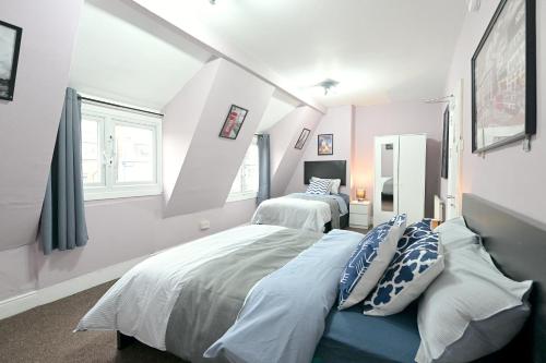 1 Schlafzimmer mit 2 Betten und 2 Fenstern in der Unterkunft STUNNING 3 Bedroom Serviced Flat IN North London in London