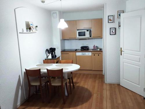 een keuken met een tafel en stoelen in een kamer bij Résidence Pic Du Midi - 2 Pièces pour 4 Personnes 744 in La Mongie