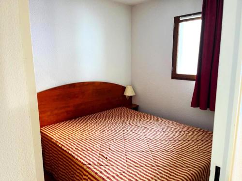 een slaapkamer met een bed in een kamer met een raam bij Résidence Pic Du Midi - 2 Pièces pour 4 Personnes 744 in La Mongie
