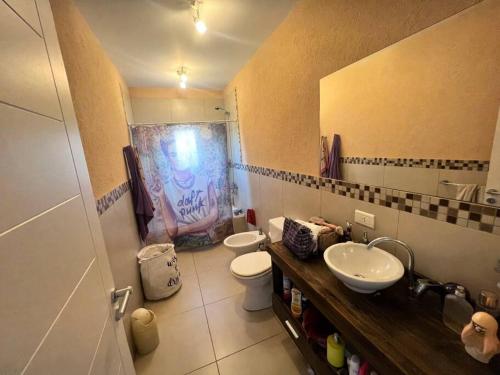 a bathroom with two sinks and a toilet and a mirror at Casa minimalista con piscina y muelle en Nordelta-Villanueva in Belén de Escobar