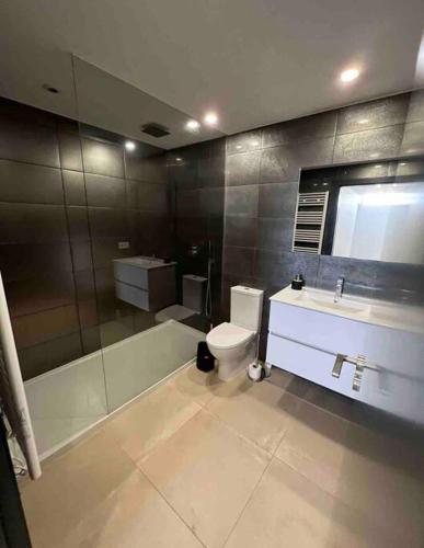 a bathroom with a tub and a toilet and a sink at Amar a Costa in Costa de Lavos