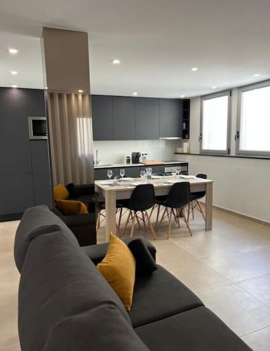 a living room with a couch and a table with chairs at Amar a Costa in Costa de Lavos