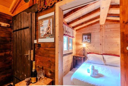a bedroom with a bed in a wooden cabin at Résidence Les Balluts - 3 Pièces pour 4 Personnes 164 in Morzine