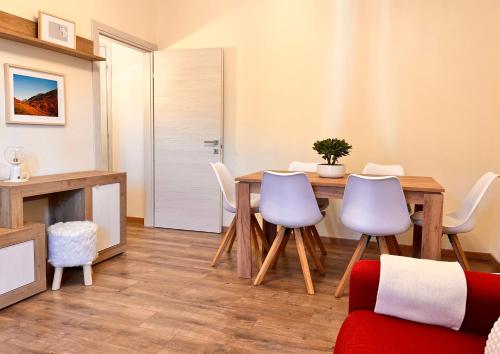 uma sala de estar com uma mesa e cadeiras de madeira em La casa del Mercato em Santa Maria Maggiore