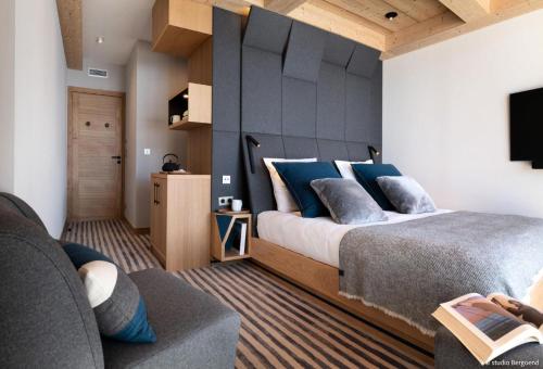 a bedroom with a large bed with blue pillows at Résidence Arpoza - Chalets pour 15 Personnes 094 in Arc 1800