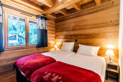 - une chambre avec 2 lits dans une cabane en rondins dans l'établissement Chalet La Passionata - Chalets pour 8 Personnes 154, à Morzine