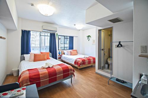 a hotel room with two beds and a bathroom at Tenmabashi Home in Osaka - Vacation STAY 16208 in Osaka